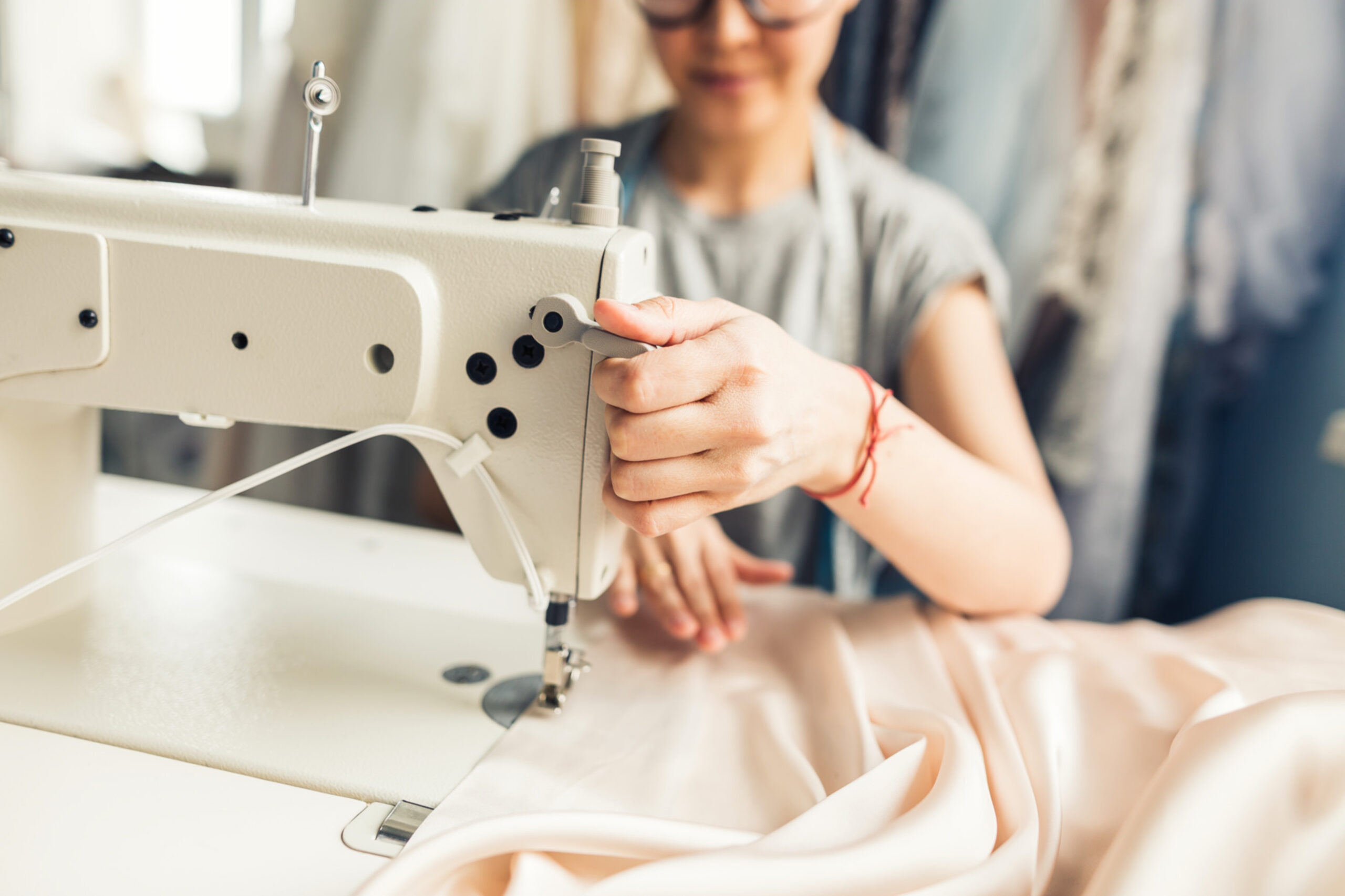 Skilled tailor meticulously repairing a denim jacket with needle and thread