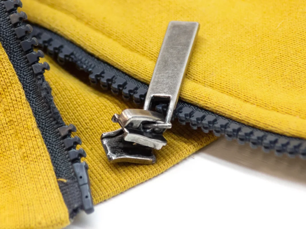 Close-up of a tailor expertly repairing a zipper on a jacket sleeve