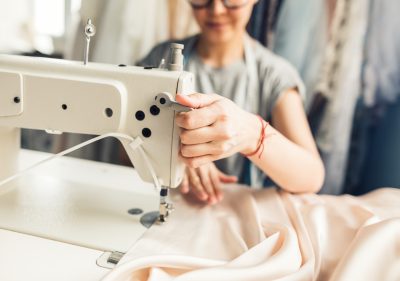 Skilled tailor meticulously repairing a denim jacket with needle and thread